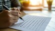 © Wiryo - Close-up of hands filling out a multiple choice answer sheet.