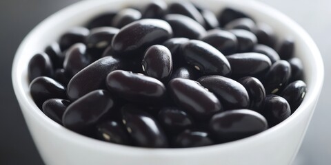 Aufkleber - A close up view of black kidney beans arranged neatly in a white bowl, highlighting the contrast and texture of the beans against the bowls color.