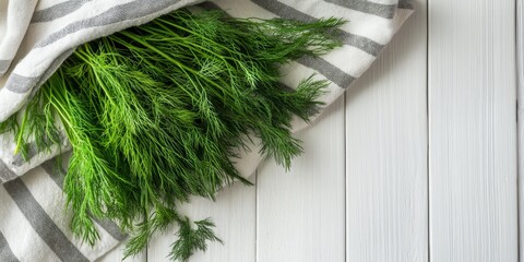 Poster - Fresh aromatic dill placed on a towel against a white wooden backdrop, highlighting the vibrant colors and textures of the fresh aromatic dill for a captivating culinary presentation.