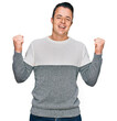 © Krakenimages.com - Handsome young man wearing casual winter sweater celebrating surprised and amazed for success with arms raised and open eyes. winner concept.
