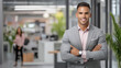 © javu - Confident businessman in modern office setting, smiling and posing