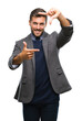 © Krakenimages.com - Young handsome business man over isolated background smiling making frame with hands and fingers with happy face. Creativity and photography concept.