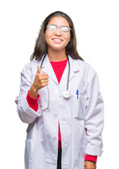 Sticker - Young arab doctor woman over isolated background doing happy thumbs up gesture with hand. Approving expression looking at the camera with showing success.