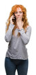 © Krakenimages.com - Young redhead woman talking on the phone cover mouth with hand shocked with shame for mistake, expression of fear, scared in silence, secret concept