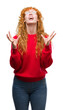 © Krakenimages.com - Young redhead woman wearing red sweater crazy and mad shouting and yelling with aggressive expression and arms raised. Frustration concept.