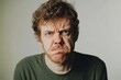 © LimeSky - Image of a distressed man with a frown reacting negatively toward the camera in a white studio setting symbolizes depression and unhappiness