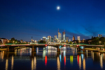 Wall Mural - Skyline view from a bridge. Metropolis with skyscrapers reflected in a river. City of Frankfurt am Main, Germany