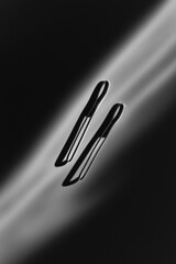 Poster - Minimalist Black and White Paper Clip Shadow Art with Textured Surface