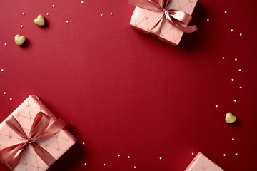 Wall Mural - Valentine's day greeting card design with elegant gift boxes, heart shaped candies, confetti on rich red background.