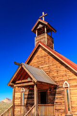 Wall Mural - A small church with a steeple and a cross on top