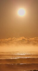 Wall Mural - sea sunrise vertical landscape, golden sun rising over misty horizon and peaceful ocean waves