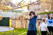© Austockphoto - First Nations Australian kid swinging on hills hoist rotary clothesline in Aussie backyard
