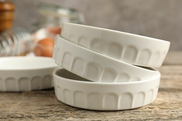 Wall Mural - Ceramic casseroles on wooden table, closeup. Cooking utensil