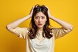 © SR Creative Idea - Stressed Young Asian Woman with Hands on Head Yellow Background