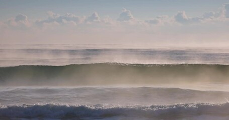 Wall Mural - sea sunrise with mist over rolling waves to the beach shore, beautiful seascape morning