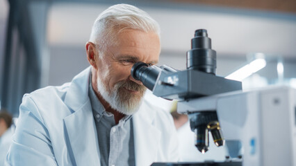 Aufkleber - Senior Medical Research Scientist Looking at Biological Samples Under a Microscope in an Applied Science Laboratory. Portrait of a Handsome Middle Aged Doctor Working on a Research Project