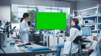 Aufkleber - Group of Students Listening to Their Young Biology Teacher Who Uses TV Monitor with Green Screen Template in a Laboratory. Team of Bioengineers Having a Meeting and Discussing Experiment Ideas