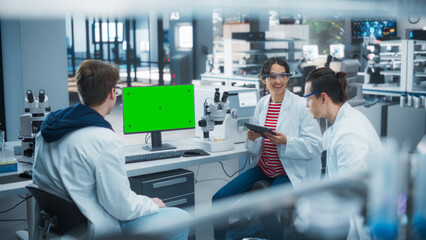 Aufkleber - Employees Looking at a Computer with Green Screen in a Science Laboratory. Female Research Scientist Having a Conversation with Two Intern Students About the Effects of Different Pharmaceutical Drugs