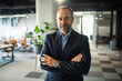 © Marko Geber - Portrait of a confident businessman in suit standing in modern office