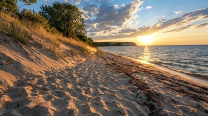 Wall Mural - serene sunset over tranquil beach with gentle waves and soft sand dunes framed by lush greenery and 