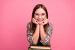 © deagreez - Charming young girl with glasses posing on a pink background with books, promoting education and casual fashion.
