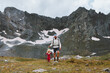 © EVERST - Family father hiking with child in rocky mountains active travel adventure vacations sport healthy lifestyle outdoor, kid climbing using trekking poles and safety harness gear