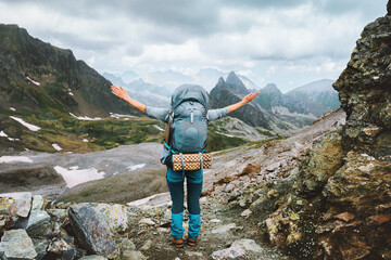 Wall Mural - Woman climbing rocky mountains travel with big backpack solo adventure lifestyle female traveler happy raised hand on summit, active vacations outdoor trip