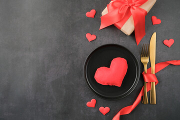 Wall Mural - table setting with heart , plate and confetti on black concrete background