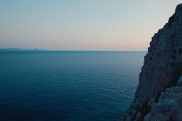 Poster - Cliffs tower over the tranquil sea at dusk, with colorful coastal plants thriving along the edge, illuminated by the soft glow of the fading sunset