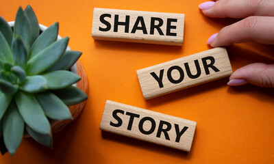 Share your story symbol. Wooden blocks with words Share your story. Beautiful orange background with succulent plant. Businessman hand. Business and Share your story concept. Copy space.