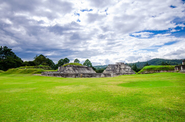 Wide view of the Mayan City of Zaculeu. Imposing pyramid-shaped buildings, surrounded by mountains close to the clouds.