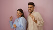 © Krakenimages.com - Man and woman dancing joyfully against a pink wall, expressing happiness and togetherness in a vibrant and isolated setting.