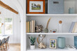© Raymond Forbes LLC/Stocksy - Modern Cottage home shelf decor with feather and frame photo