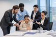 © Liubomir - Colleagues support upset sad woman. Diverse business team at workplace comforting female employee.