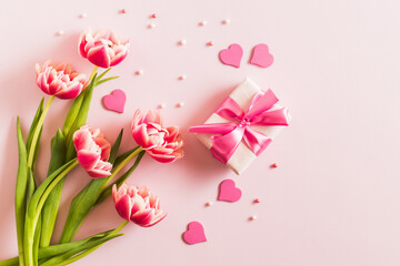 Wall Mural - Pink tulips and hearts, gift box with ribbon on light pink background