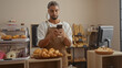 © Krakenimages.com - Young man with a beard using a smartphone in a bakery shop surrounded by pastries and bread displays.