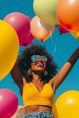 Wall Mural - African American young striking woman holding many colorful balloons in her hands and rising from the ground. She is happy and laughing