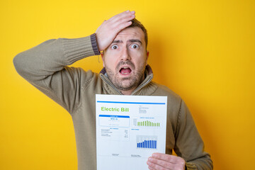 Wall Mural - One man worried about bills reading energy increase costs isolated on yellow background