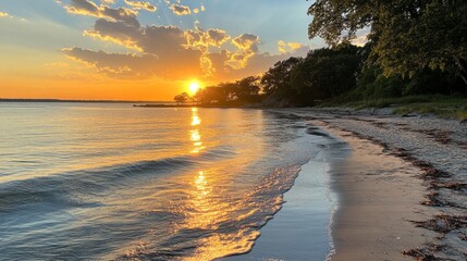 Poster - Golden rays filter through soft clouds as the sun descends on a tranquil beach. Gentle waves lap at the shore, creating a peaceful atmosphere perfect for contemplation and admiration