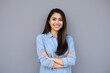 © mamo studios - Portrait of a young latin woman with pleasant smile, isolated on grey wall with copy space. Cheerful hispanic woman on grey background with copy space.