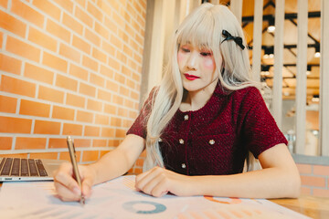 Poster - Young Asian Woman with Long Blonde Hair Working on Business Documents