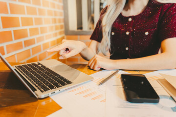 Poster - Woman Working on Laptop in Cozy Office with Papers and Smartphone Nearby