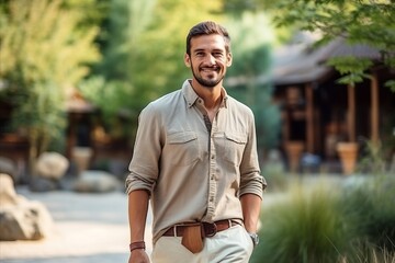 Wall Mural - Portrait of a handsome young man smiling at the camera while standing outdoors