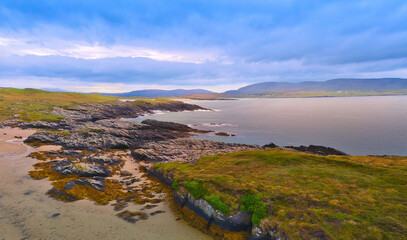 Wall Mural - Beautiful Ireland - A breathtaking view showcasing rocky cliffs meeting calm, gentle waters beneath a vast, clear blue sky