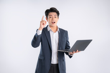 Wall Mural - Portrait of young Asian business man using laptop and posing on white background