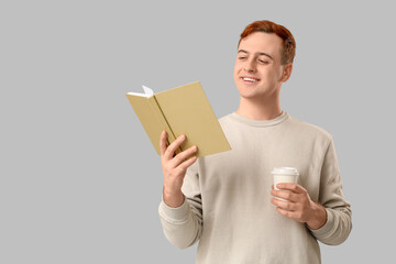 Wall Mural - Young man reading book and holding cup of coffee on grey background