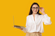 © Pixel-Shot - Pretty young woman with modern laptop on yellow background