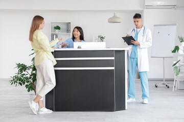 Sticker - Medical intern working with patient and doctor at reception in clinic