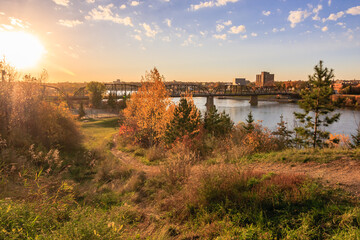 Wall Mural - A bridge spans a river with a city in the background