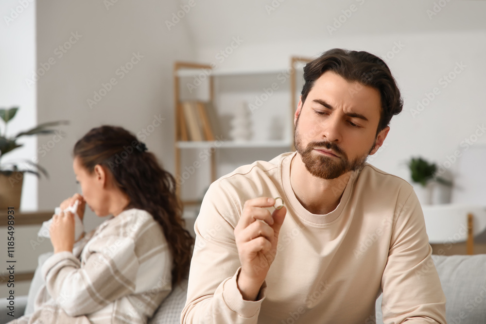 Unhappy man with his wedding ring at home. Divorce concept